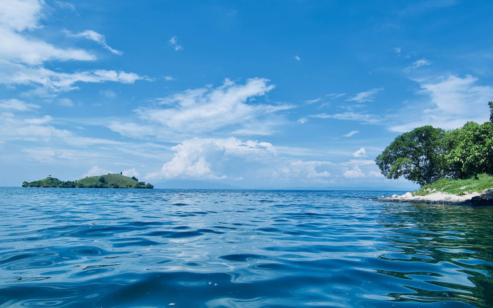 Serene blue sea under a bright sky with distant green islands